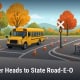 Fostoria News Yellow school bus on road with traffic cones and crossing sign in autumn setting.